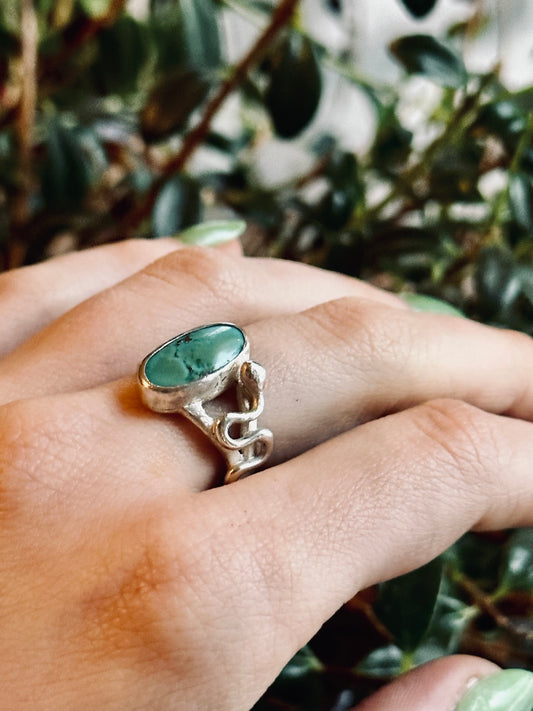 sterling silver ring, oval turquoise stone, set vertically split shank band with silver snake crawling up one side of the ring